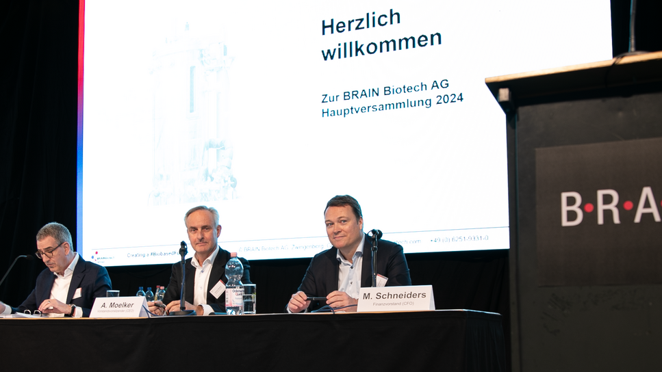 Sitting on a podium: Dr. Michael Majerus (Chairman of the Supervisory Board), Adriaan Moelker (CEO) and Michael Schneiders (CFO) during the Annual General Meeting.